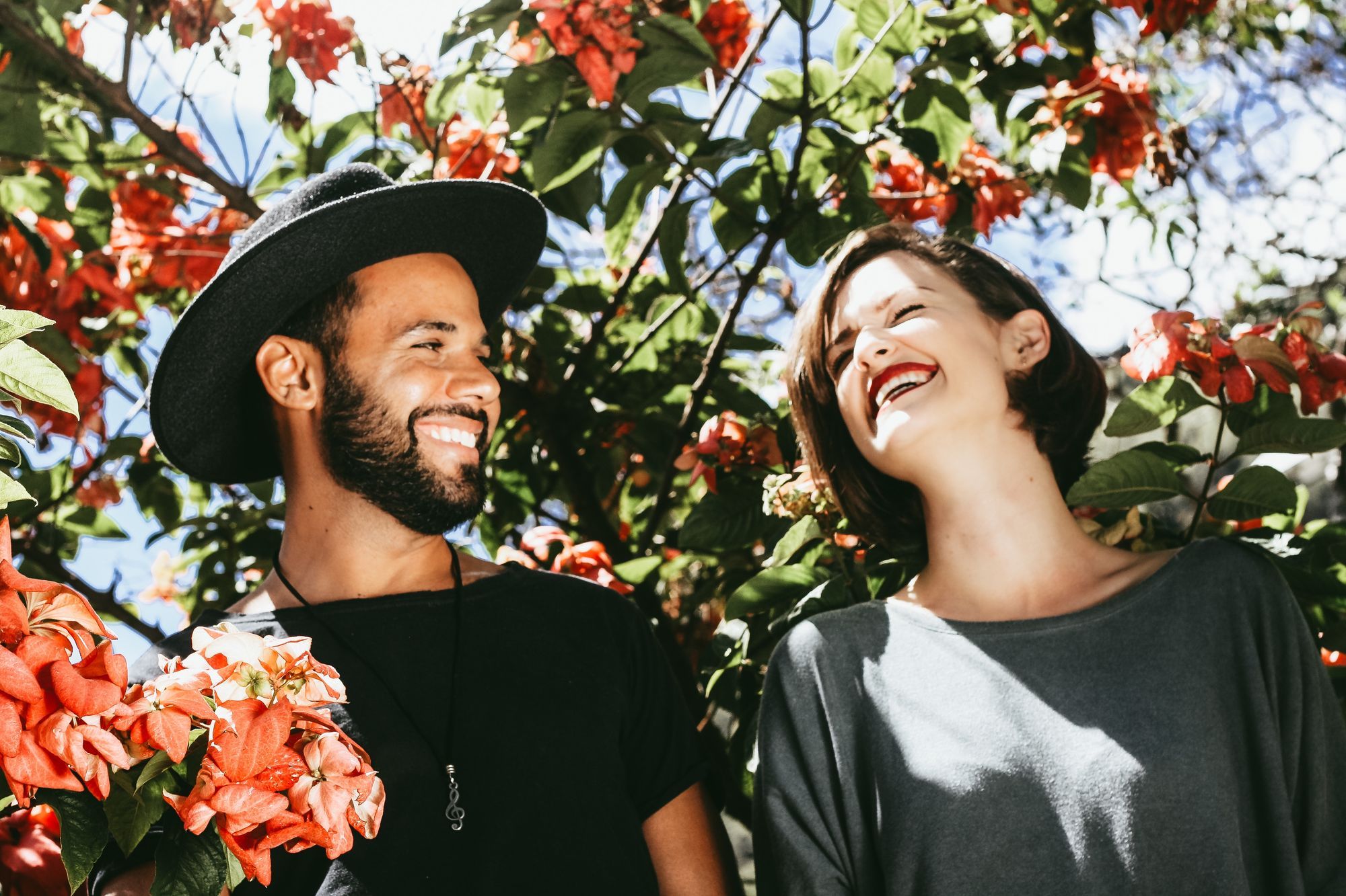 a dark skinned person and a light skinned person smiling at each other