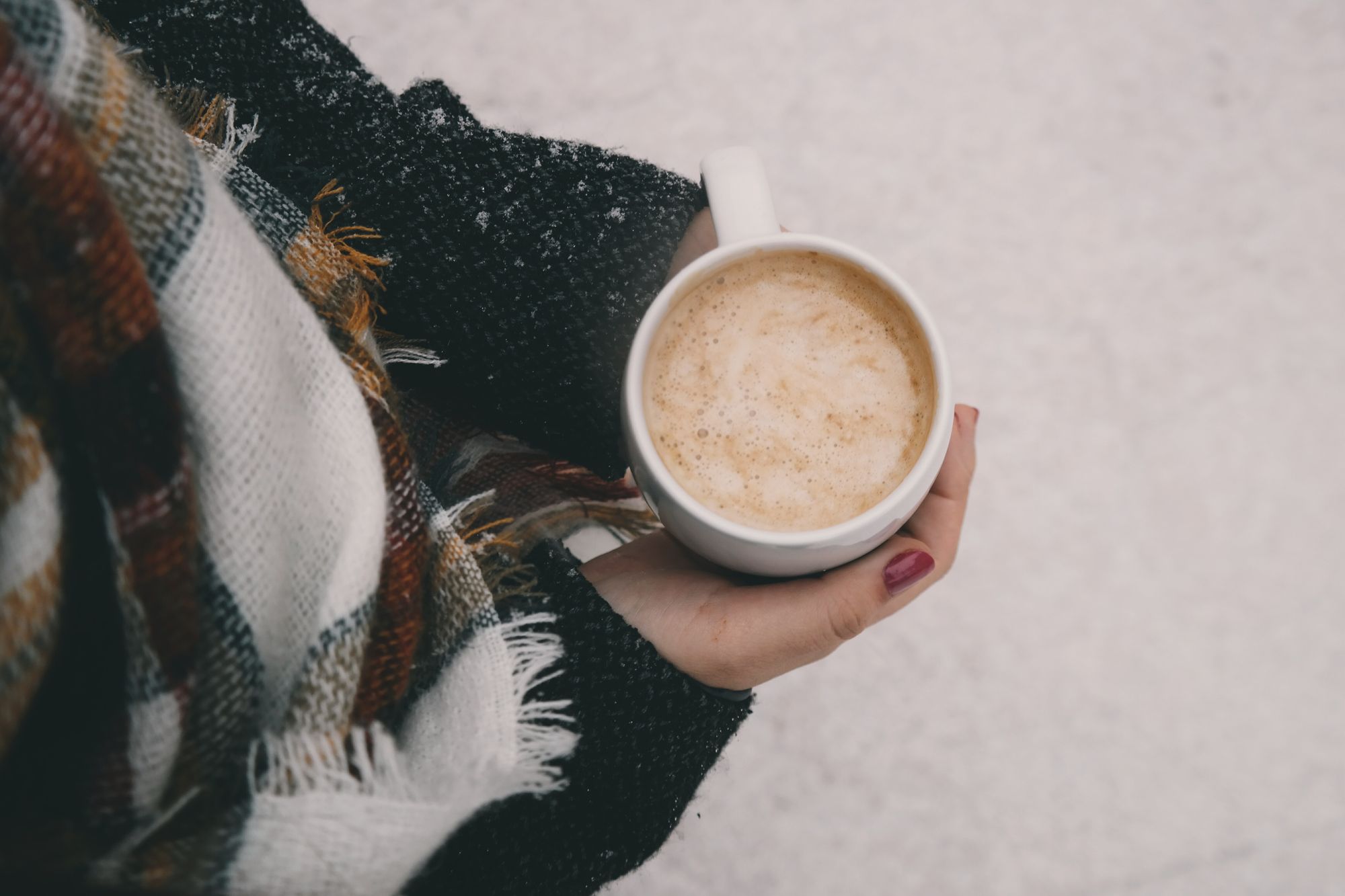 Woman holding coffee in a winter setting