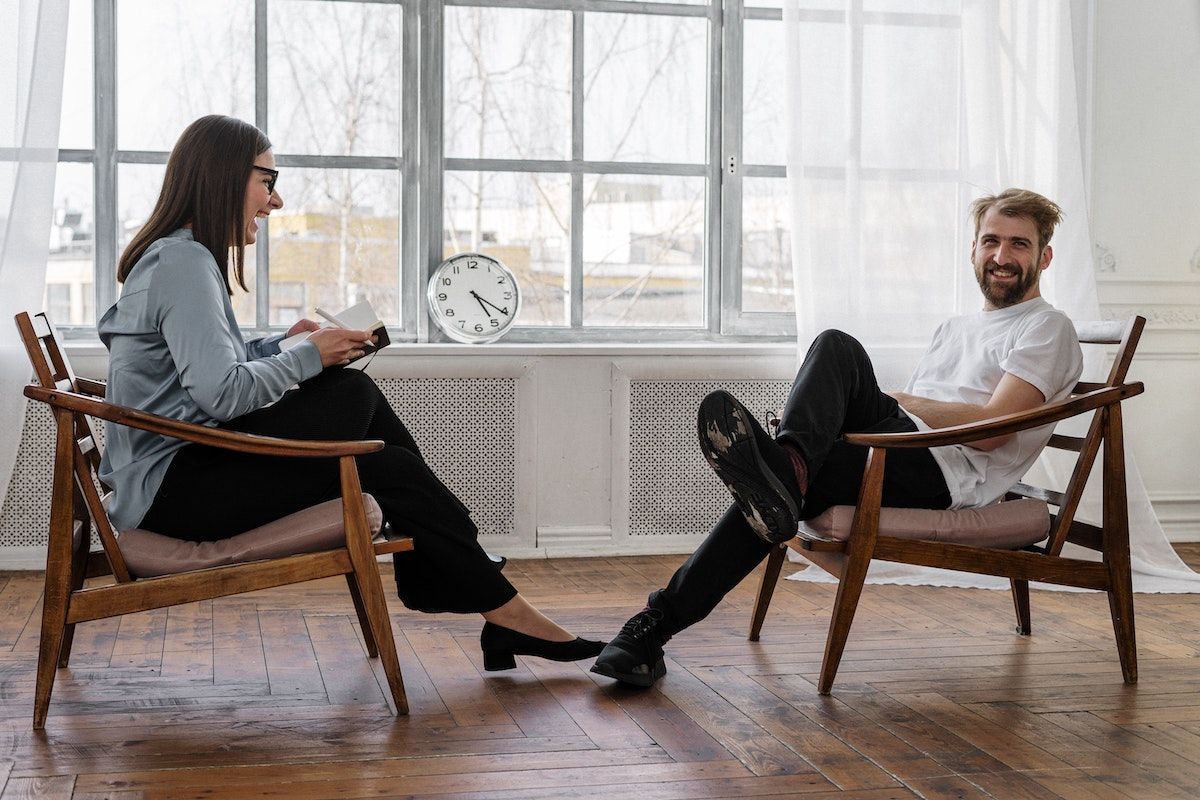Therapist and client sitting across from each other in session, laughing