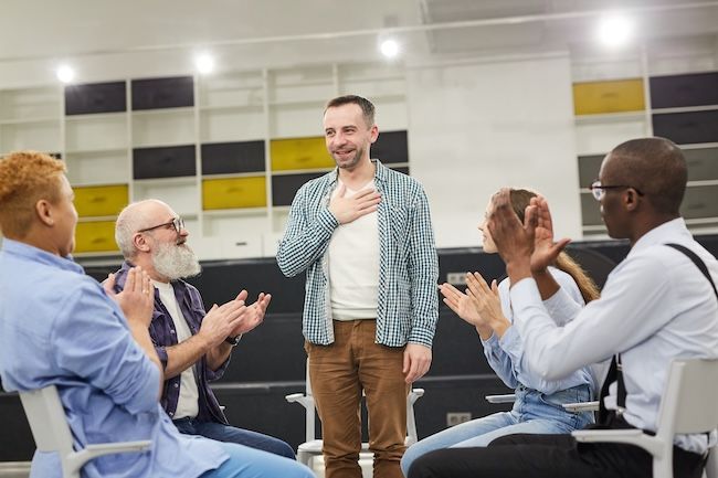 a group of people applauding one person