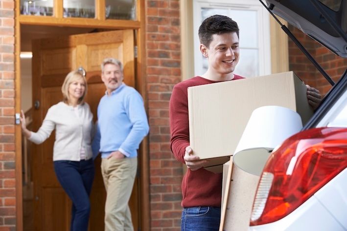 parents watching their child pack up a car to leave for college